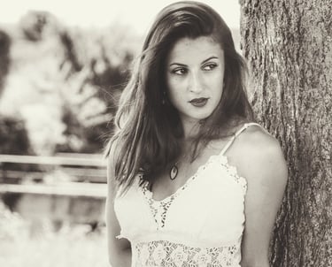 Une jeune belle femme adossée à un arbre