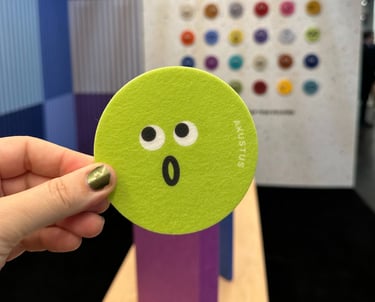 cute emoji face in front of multicolored acoustic wall