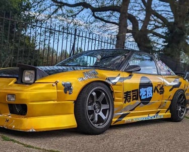 a yellow car with a large number of stickers on it