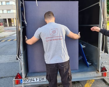a man is moving a couch into a moving truck