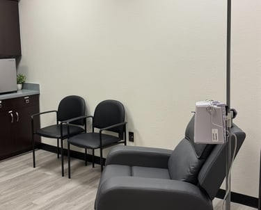 Infusion treatment room with a reclining chair and IV setup for neurological therapies and migraine infusions.