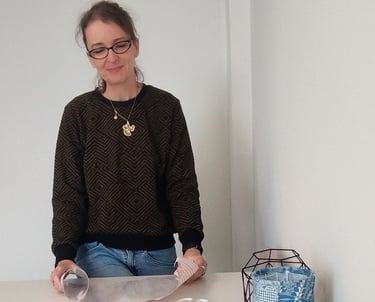 a woman sitting at a table with a paper bag