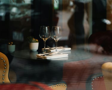 a table with a plate of food and wine glasses