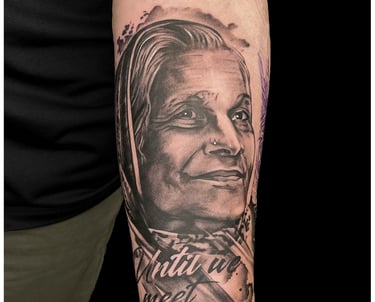 Photo of a portrait tattoo of a women on the arm