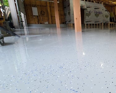 Glossy epoxy with sporadic flake install with smooth seamless floor with 45 degree coving 