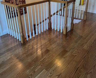 a staircase way with a hardwood floor and a wooden railing
