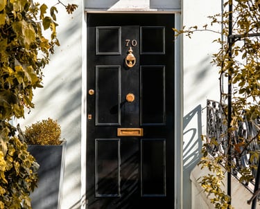 a black door with a black door and gold numbering