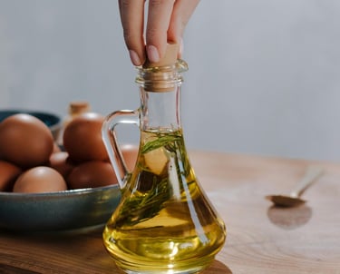 Imagen generica de mano tapando una botella con aceite y hiervas