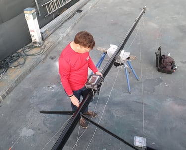 NDT technician performing ultrasonic testing on a yacht mast