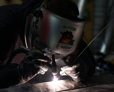 a man welding a metal object in a factory