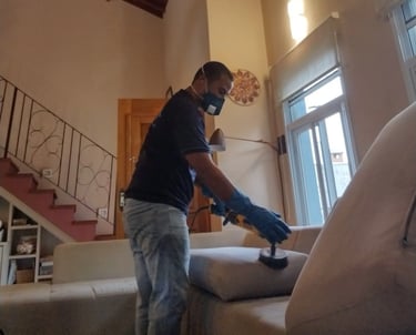 Limpeza de sofá bege em Campinas -procedimento técnico com escovação e proteção individual.