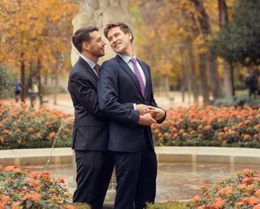 Pareja de recién casados gays frente a una fuente, abrazándose con amor. Gay marriage Spain.