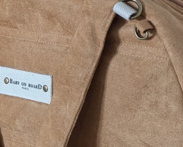 Un sac à langer de couleur camel, conçu dans une matière suédine.