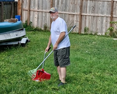 Robert using a sanitized scooper to remove waste from a customers back yard