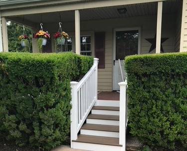 Front porch steps in composite deck boards and vinyl posts and railings installed by Golden Rule 