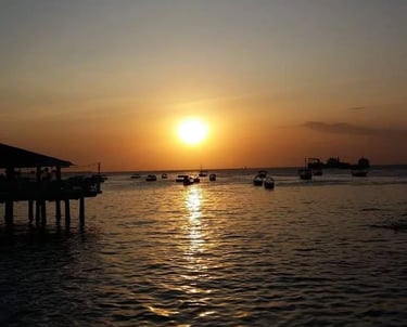 raditional dhow sailing through calm Zanzibar waters during a vibrant sunset.