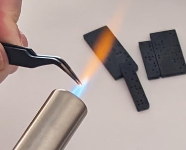 Thermosoudure avec une pince chauffée au chalumeau, utilisé pour fixer des billes d'acier