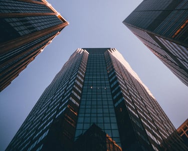 Photograph of a towering office building with blue sky above