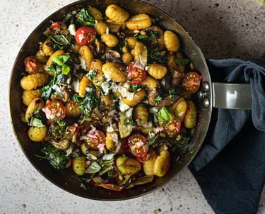 pan of gnocchi, cherry tomatoes, parmesan and basil