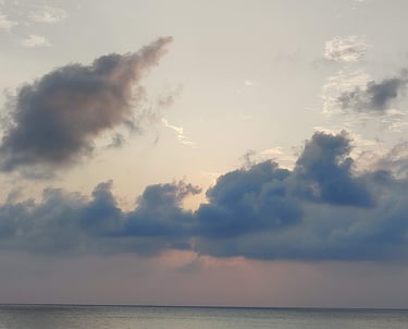 Andaman trip details - Poetic view of soft clouds over a quiet horizon at dusk, capturing the island