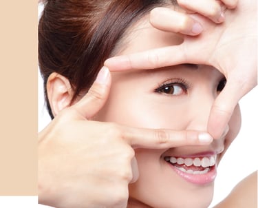 Smiling woman with clear skin and white teeth framing her face for skincare and beauty results.