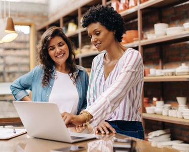 Empresária e vendedora analisando finanças da loja, ilustrando o BPO Financeiro e Gestão Empresarial