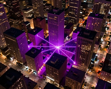 An aerial view of a neon-lit North American city at night, with glowing purple and magenta highlights following the street grid, symbolizing connectivity.