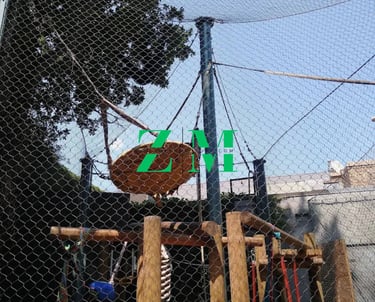 An outdoor adventure playground featuring a climbing frame, rope bridge, and safety netting.
