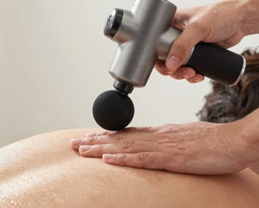 Close-up of an athlete’s leg being massaged deeply by a sleek, modern sports massager.