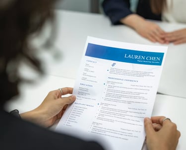 A person holding a professional resume for a Digital Marketing Specialist during a job interview.