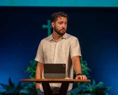 Pastor standing at pulpit relaxed.