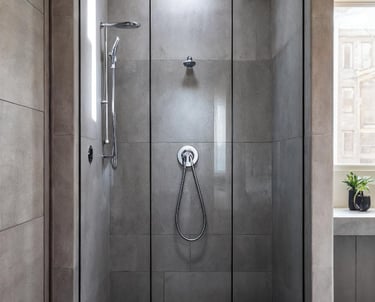 Dark‑grey frameless shower with hexagonal floor tiles ,style of frameless shower FixShowers services
