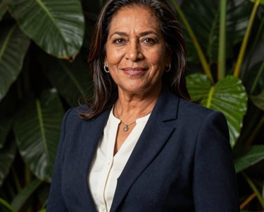 A professional portrait of a South American woman in her 50s, representing Elsa Antonelli. She is dressed in elegant but practical attire, standing in front of a backdrop of lush green foliage. Her expression is warm and professional, embodying the brand's heritage.