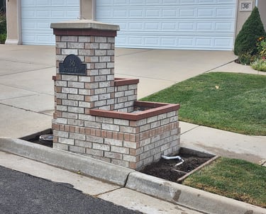 Brick pillar with attached planter box and address plate