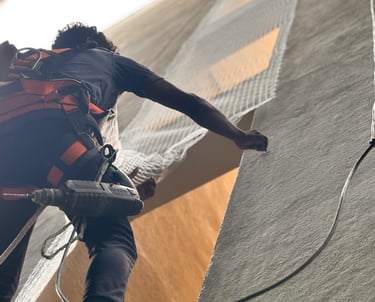 Technician carefully installing a sturdy safety net on a high-rise building duct in Bengaluru.
