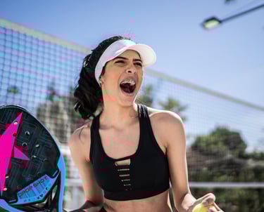 Atleta de beach tennis comemorando um ponto ganho na partida.