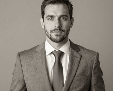 Professional headshot of a confident businessman in a grey suit and tie.