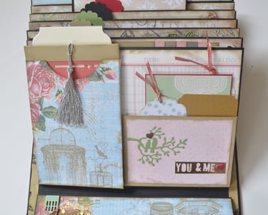 Handmade vintage scrapbook with decorative floral pockets, silver tassels, and paper tags for journaling.