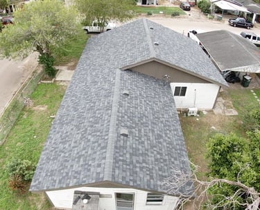 Aerial view of a residential home featuring a newly installed gray asphalt shingle roof.