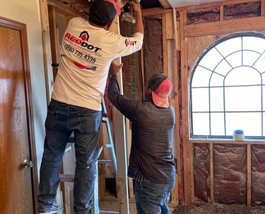 Professional contractors installing wood wall framing during a home interior renovation project.