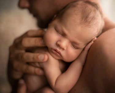 Noworodek w objęciach taty  fotografia noworodkowa.