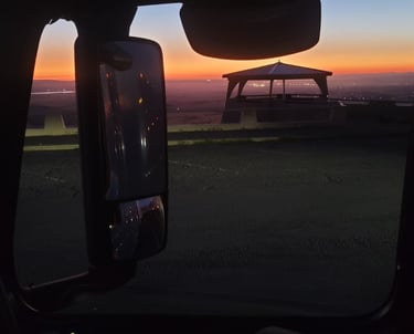 Impresionante vista del atardecer desde un camion, mostrando un pabellón y los vibrantes colores d