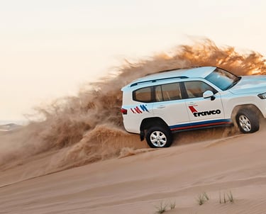 a white suv driving through a desert
