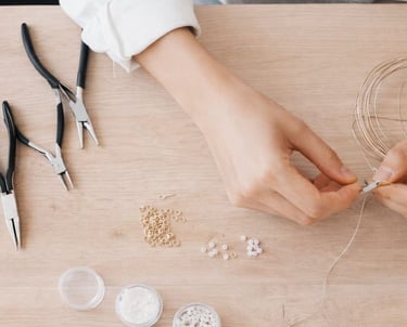  Joyera que utiliza alicates y alambre para crear accesorios hechos a mano con cuentas