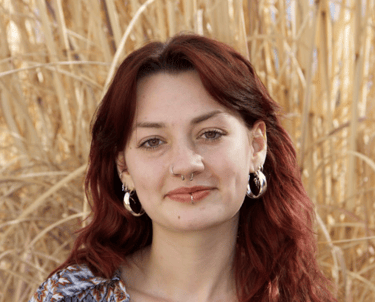 Headshot of Zinnia Crowley in a blue and maroon blouse.