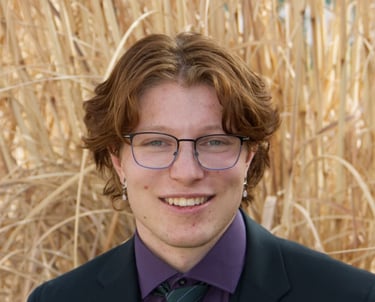 Headshot of Yishai Trowbridge in a black suit.