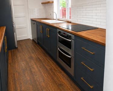 Navy blue shaker kitchen cabinets with solid wood worktops and gold handles fitted in Kidlington.
