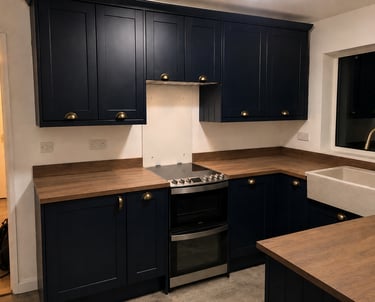 Navy shaker-style kitchen cabinets with brass handles, wood-effect countertops, fitted in Abingdon