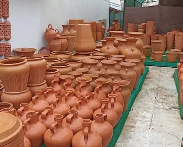 A large display of traditional terracotta pottery and handmade ceramic clay pots for sale.