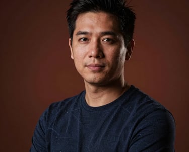 Portrait of a creative lead in a dark studio. Moody lighting with a subtle terracotta backlight. Professional and focused atmosphere.